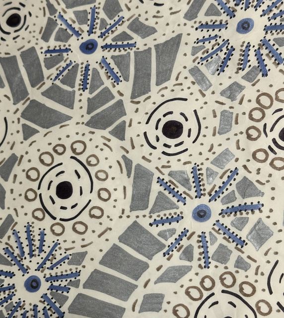 Grey mosaic shapes with blue starburst forms and dotted rings