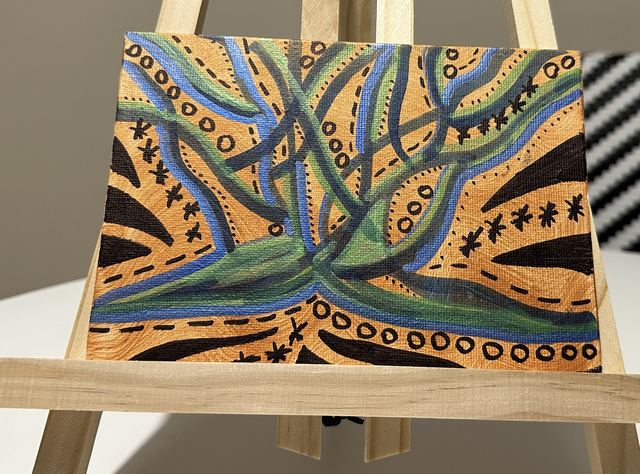 Blue and green branching lines over an orange and black patterned ground