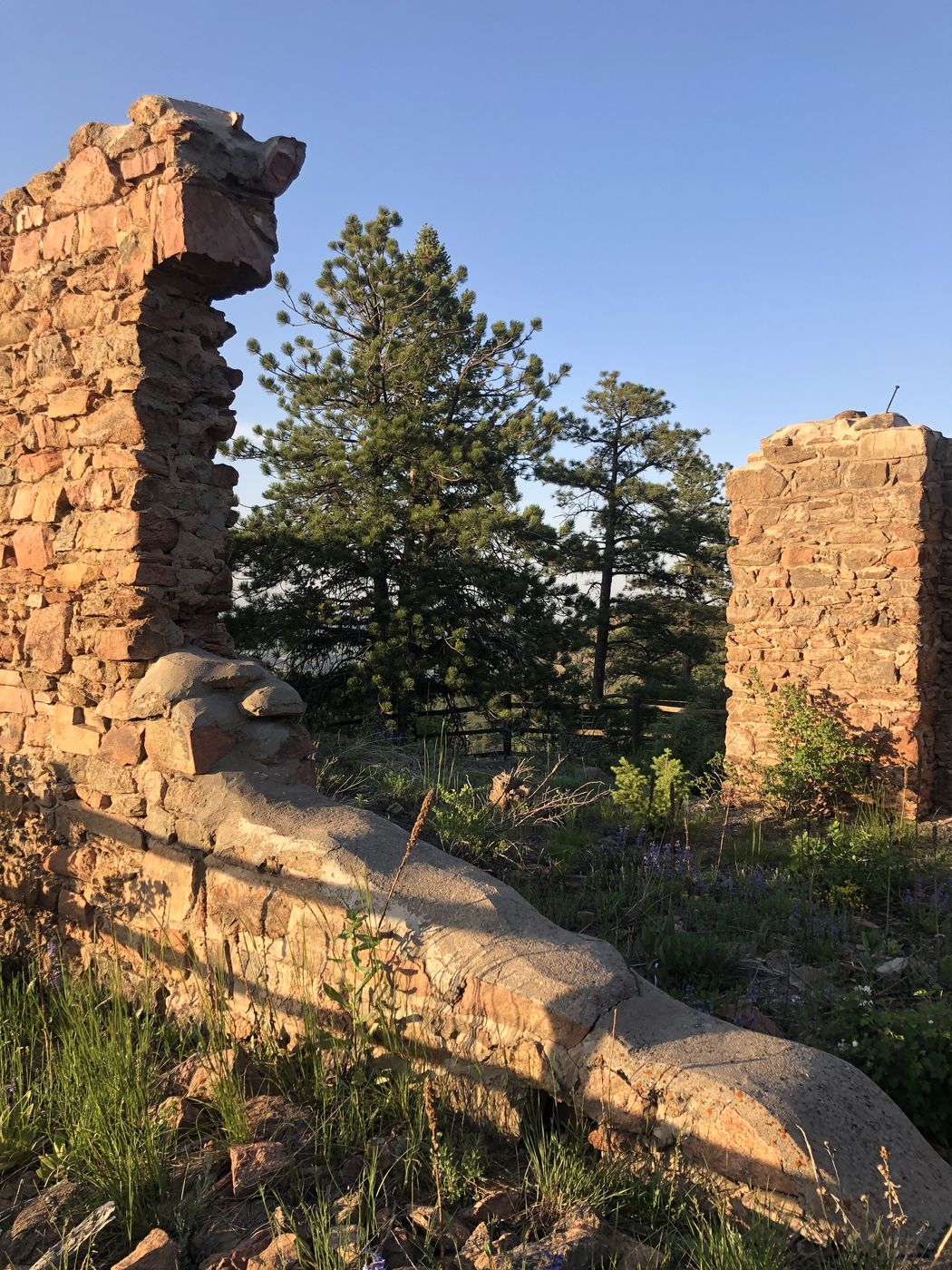 Crumbling stone ruins catching warm sunlight against a blue sky